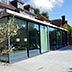 Full width glass extension with retractable doors creates a truly inside / outside experience