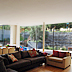 Dug out terrace and stone clad retaining wall act as the fourth wall of the living room through full height windows